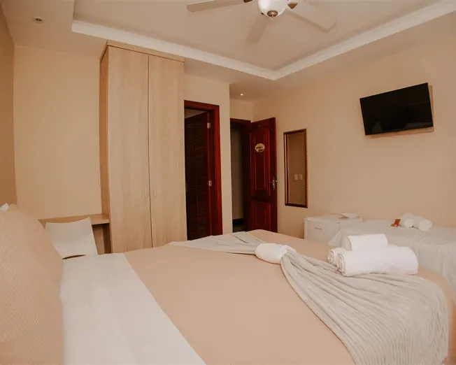 Quarto quádruplo amplo com cama de casal e camas de solteiro