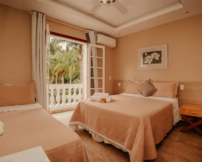 Quarto triplo com cama de casal, cama de solteiro e sacada